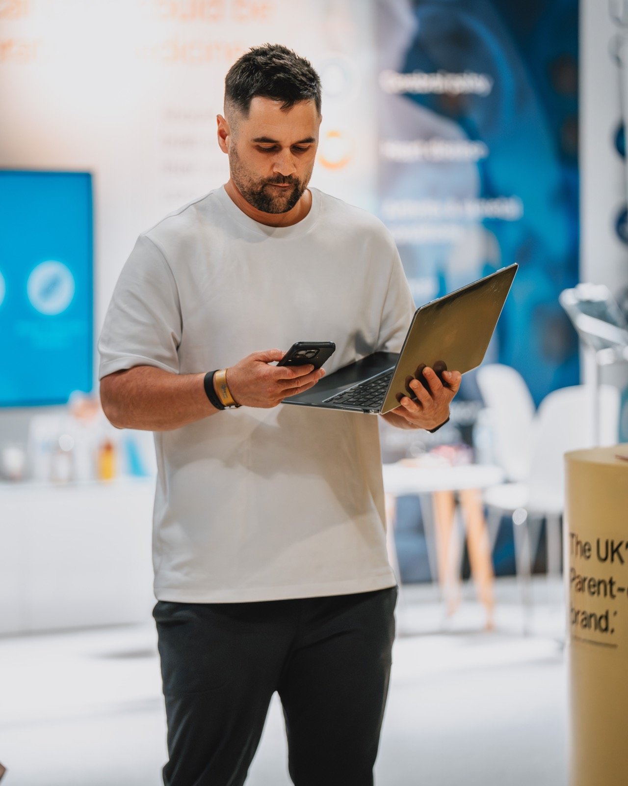 A clinic founder working across a phone and laptop
